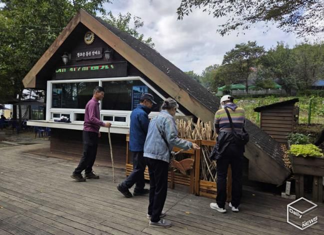 등산객들이 광교산 등산 안내소 앞에 있는 지팡이를 고르고 있다.
